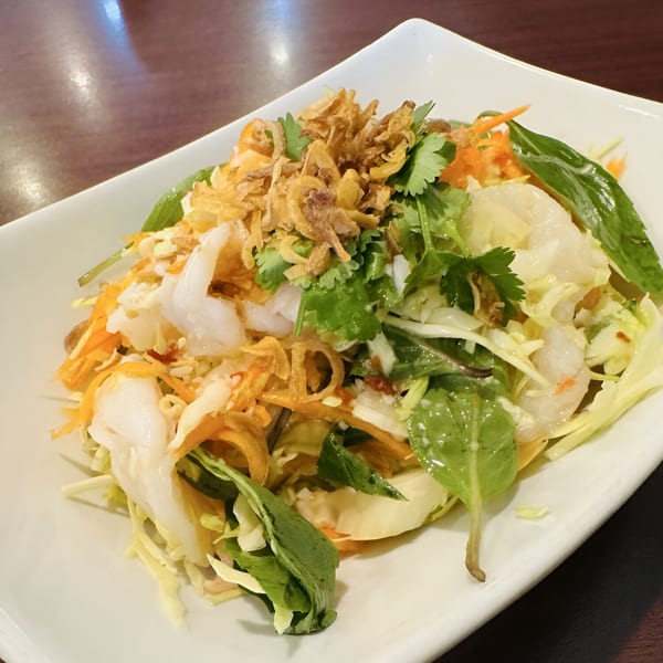 Thai salad with shrimp, shredded cabbage, carrots, herbs, and crispy fried onions.